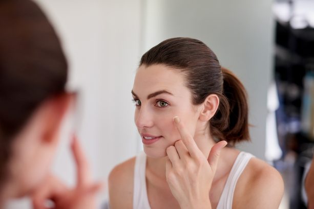 Young woman applying face cream