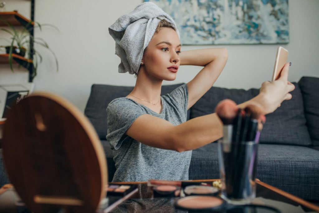 Woman Takes Selfie Doing Hair and Makeup After Cosmetic Procedure