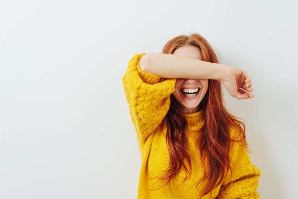 Woman smiling and raising arm after brachioplasty surgery